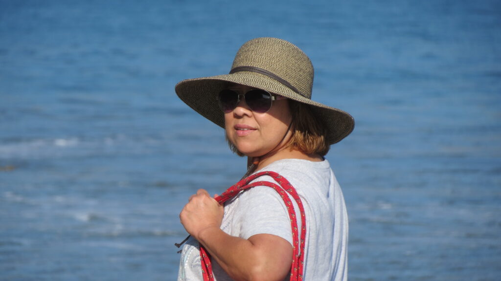 Norela wearing a hat and sunglasses at Rincon Beach, California